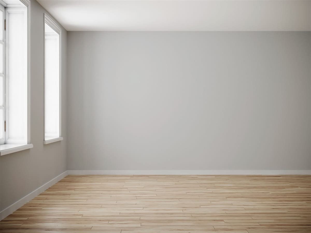 Lege kamer met glad bezette muren, twee ramen en een houten vloer