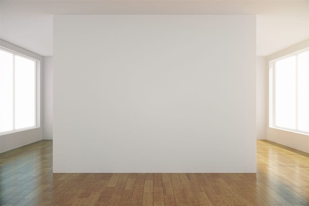 Vlak bezette witte wand tussen twee ramen, met houten vloer